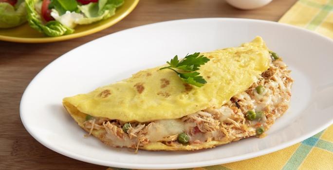 Foto da Receita de Omelete com Sobras de Frango. Observa-se uma omelete recheada com frango em um prato branco.