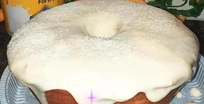 Foto da receita de Bolo de Ninho. Observa-se um bolo assado com furo no meio e bastante cobertura polvilhada de Leite Ninho