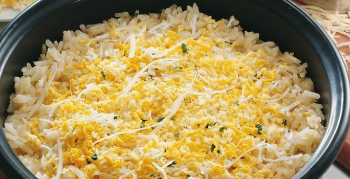 Uma panela comporta o arroz em tons amarelos.