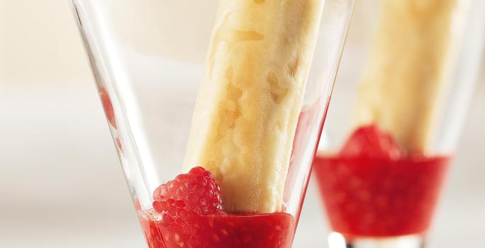 fotografia em tons de branco e vermelho tirada de duas taças. Dentro contém o Coulis de Frutas e o crocante.