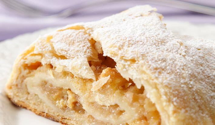 foto tirada de um pedaço de torta com recheio de maçã e polvilhado com açúcar