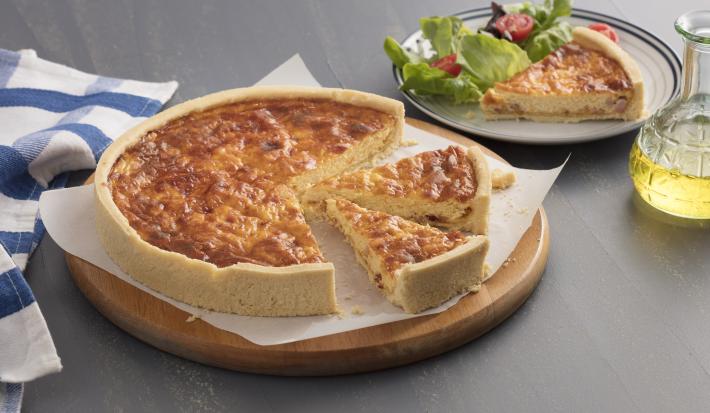 Torta servida em um recipiente retangular cor branco e abaixo um pano branco.