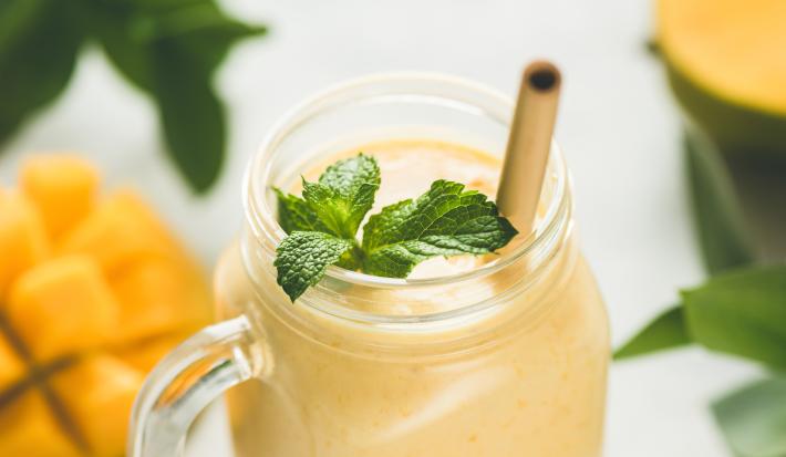 Contém um copo transparente com a vitamina de maracujá e um canudo marrom para servir