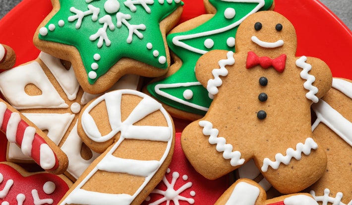 Biscoitos de Natal em formato de boneco, estrela, árvore e bengala decorados com glacê colorido.