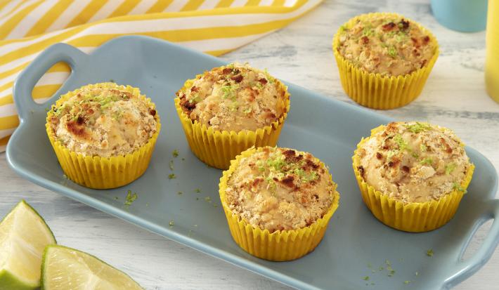 Foto da receita de Muffin de Limão. Observa-se uma bandeja de porcelana azul claro com 4 muffins em forminhas amarelas em cima, polvilhados com limão e NINHO em Pó.