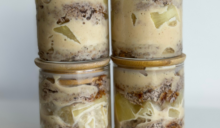 Fotografia mostra um pote transparente, dando visibilidade para o bolo, recheio e pedaços de abacaxi.