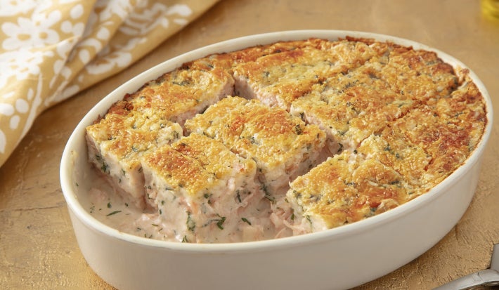 Caçarola assada de atum e salmão em molho cremoso, com superfície dourada gratinada, servida em refratário oval branco.