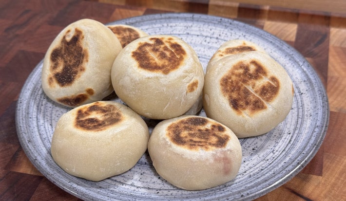 imagem mostra pequenos pãezinhos brancos e dourados sobre uma superfície
