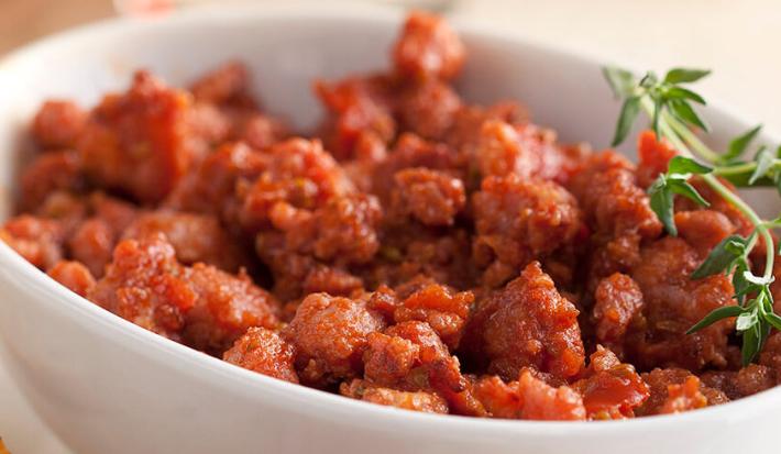um recipiente branco comporta o ragu de linguiça toscana.