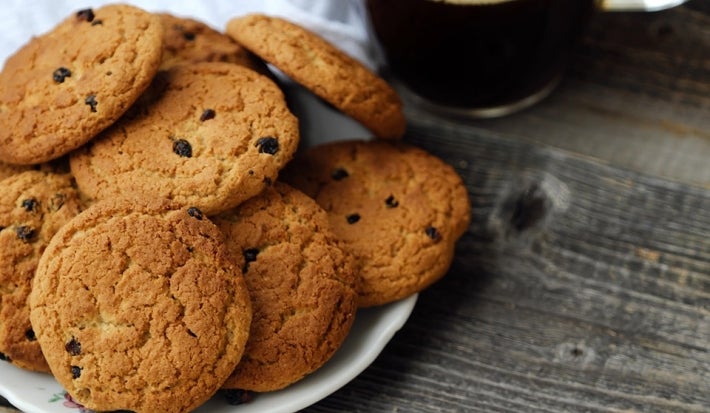 Em cima de uma mesa, prato com biscoitos em redondos crocantes e dourados.