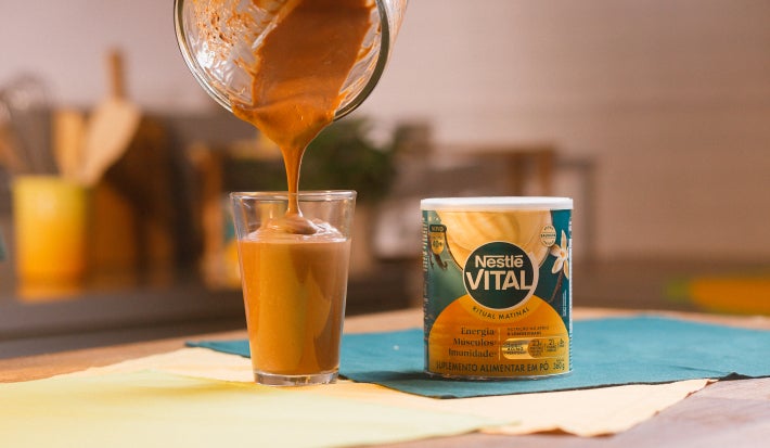 imagem mostra um copo de refresco de café cremoso, com coloração marrom e acabamento de canela