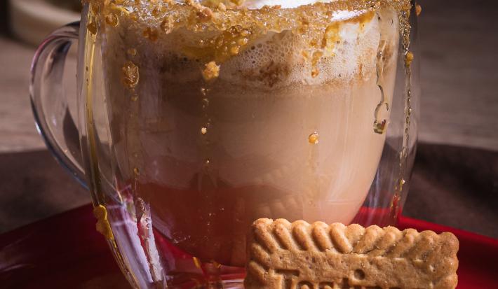 Foto da receita de cappuccino caramelo salgado servida em um copo de vidro sobre uma mesa de madeira