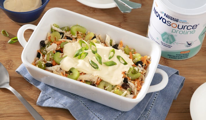 Fotografia mostra travessa com salpicão, visivelmente colorido com cenoura, salsão e uvas passas, com pedaços de frango, por cima o creme. Fotografia mostra travessa com salpicão, visivelmente colorido com cenoura, salsão e uvas passas, com pedaços de frango, por cima o creme.