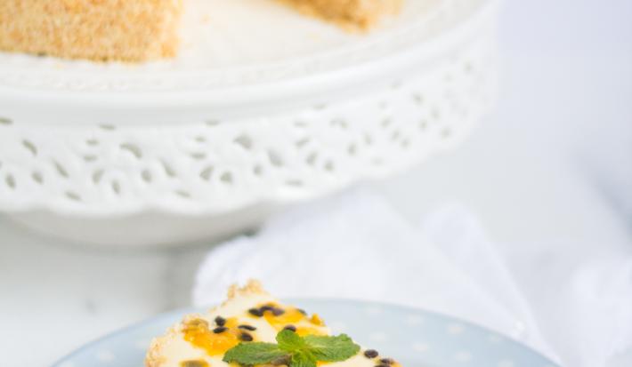 fotografia em tons de branco e amarelo tirada de uma torta com uma fatia retirada, à frente um prato redondo com a fatia de torta e um garfo para servir.