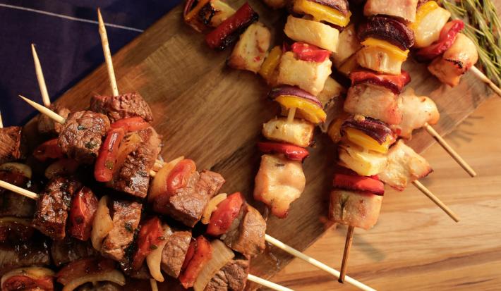 Foto de vários espetinhos de carne e de frango, um em cima do outro