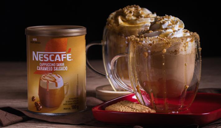 Foto da receita de cappuccino caramelo salgado servida em dois copos de vidro sobre uma mesa de madeira