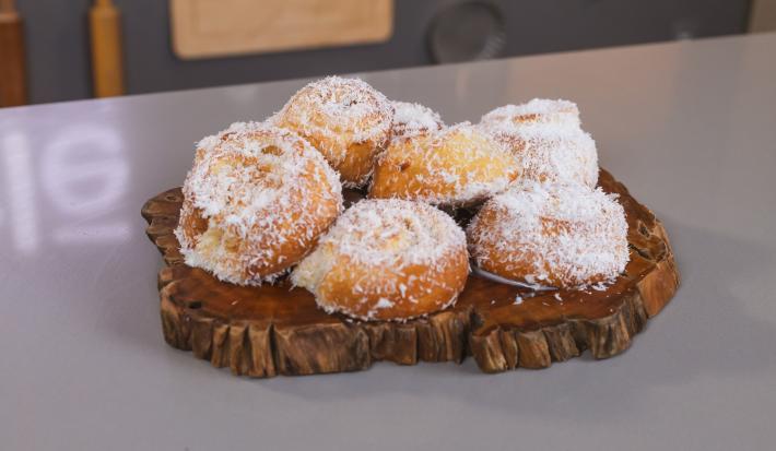 Foto da receita de Fatias Húngaras, servidas sobre uma tábua de madeira e decoradas com coco ralado