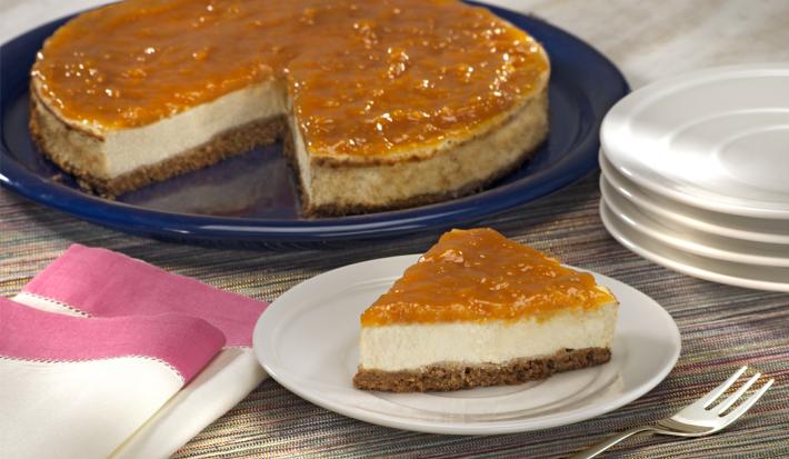 fotografia em tons de cinza, branco e azul de uma bancada cinza vista de frente. Contém um prato redondo e branco com uma fatia de torta ao fundo um prato redondo azul com a torta faltando uma fatia. Ao lado pratos brancos e um pano branco com rosa.