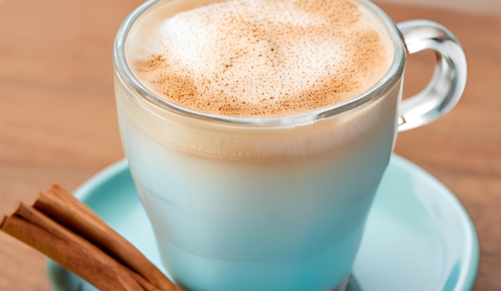 Foto da receita de Café Gelado Proteico. Observa-se uma xícara de vidro com a bebida dentro, polvilhada de canela. Foto gerada por IA.