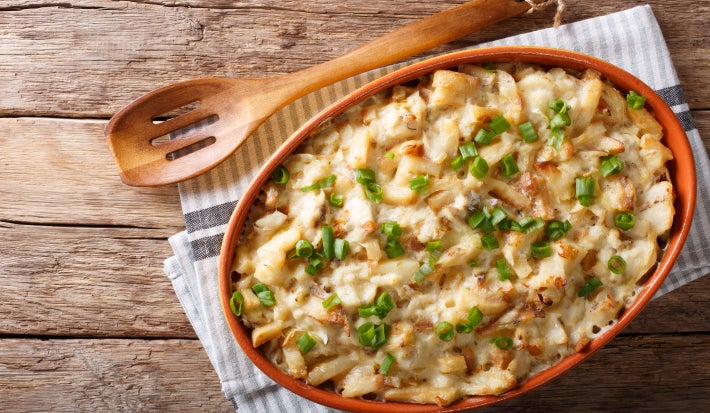 Bacalhau com natas gratinado em refratário oval, coberto com queijo dourado e cebolinha picada.