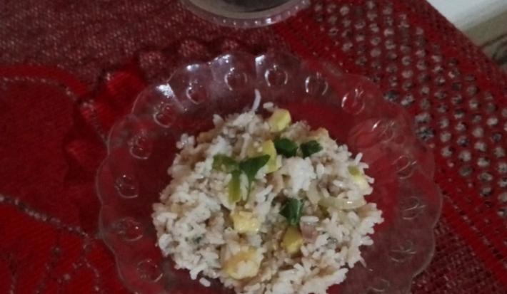 Fotografia de um prato de vidro sobre um pano vermelho, dentro do prato tem arroz com lentilha e abobrinha.