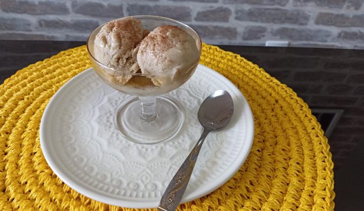 Imagem da receita de Sorvete nutritivo de banana com 3 ingredientes, em um prato branco, sobre uma mesa e ao lado os talheres
