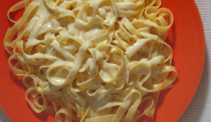 foto em tons branco e laranja. Um prato na cor laranja, comporta o macarrão. foto em tons branco e laranja. Um prato na cor laranja, comporta o macarrão.