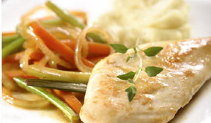 Em um prato quadrado e branco contém um pedaço de frango servido com cenoura, cebola e salsão.