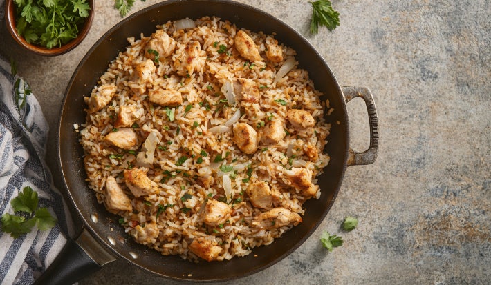 Fotografia de uma receita de arroz com frango feitos em uma panela de ferro