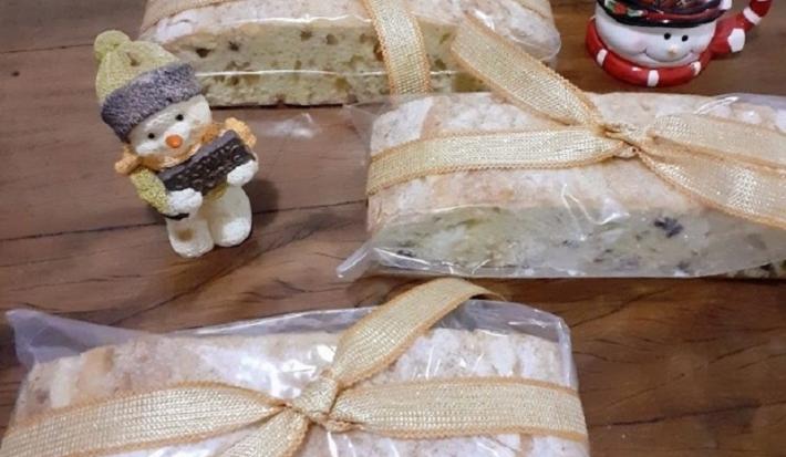 Foto da receita de bolo de natal servida em três porções sobre uma mesa de madeira com decorações de natal como bonecos de neve