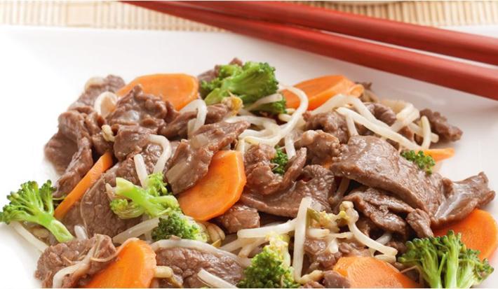 foto tirada de um prato quadrado branco com pedaços de carne, cenoura e brócolis