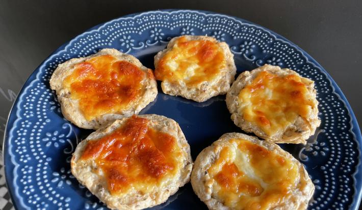 Imagem da receita de Esfiha de Ricota sem Glúten em um prato azul sobre uma mesa