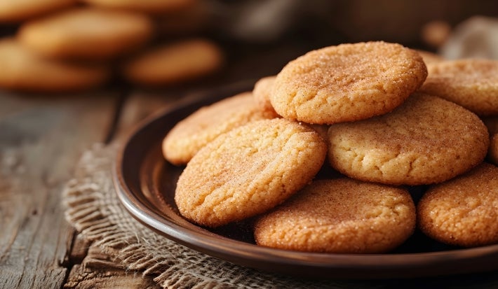 Em cima de uma mesa, biscoitos redondo crocantes e dourados.