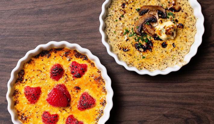 Fotografia vista de cima de dois ramekins de cremes brulée, um de cogumelo com gorgonzola e o outro de baunilha com framboesa. As sobremesas estão sobre uma mesa de madeira.