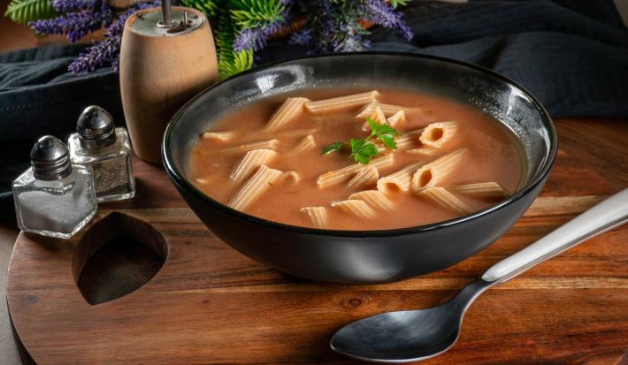 Fotografia de uma sopa feita com massa penne e vegetais