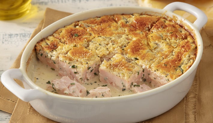 Caçarola assada de atum e salmão em molho cremoso, com superfície dourada gratinada, servida em refratário oval branco.