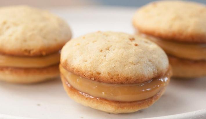 3 Whoopie de Banana com recheio de Doce de Leite por cima de um prato redondo e branco.