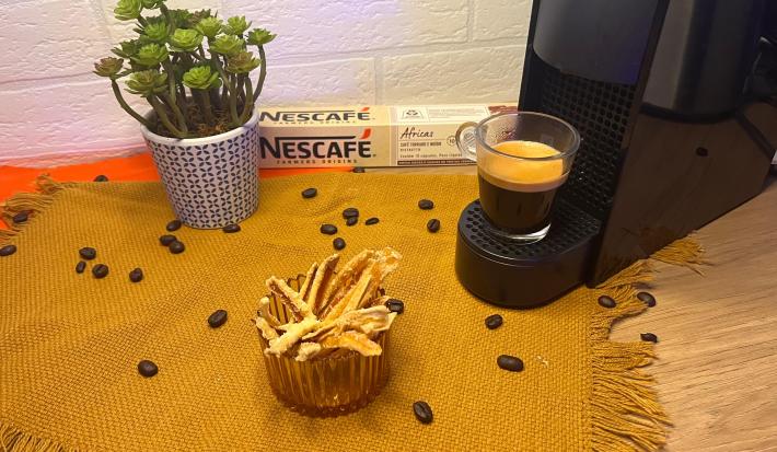 Fotografia em tons de laranja com uma cafeteira ao centro. Ao lado da cafeteira existe um pote com casca de laranjas cristalizadas.