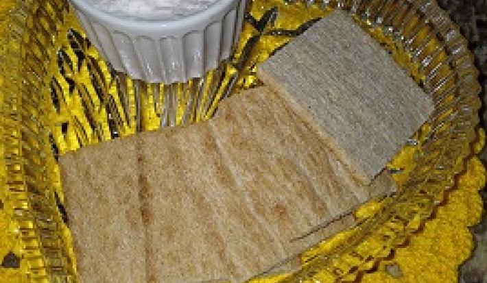 Foto da receita de Patê de Peito de Peru. Observa-se um recipiente transparente com 4 torradas em cima e, ao lado, um potinho com o patê.