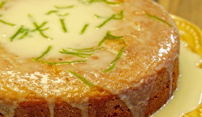 Bolo de limão caseiro com calda e cobertura de açúcar, raspas de limão e prato amarelo