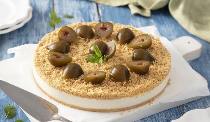Foto da Receita de Torta de Ricota com Figo. Observa-se a torta sobre uma tábua branca e uma superfície de tábua azul clara.
