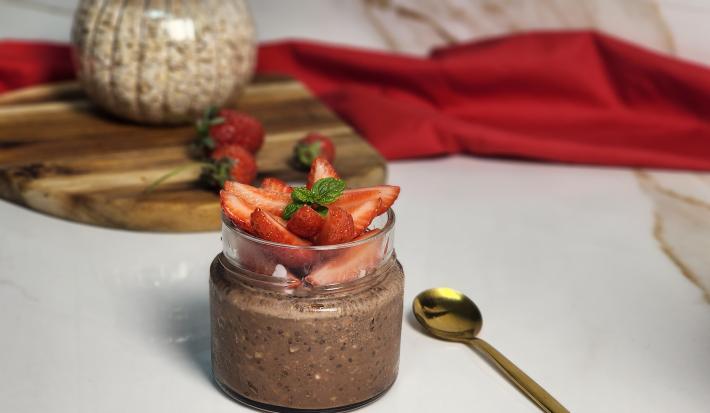 Foto da receita de Overnight Oats de Nescau. Observa-se um pote de vidro com o overnight dentro, decorado com morangos picados em cima.