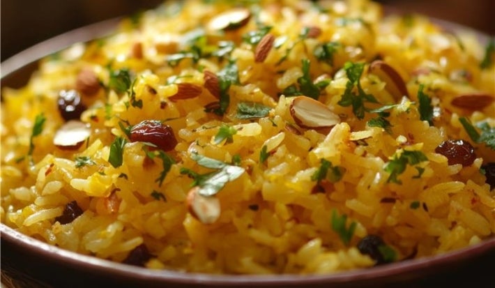 Tigela redonda com porção de arroz amarelo e soltinho com amêndoas picadas, decorado com coentro picada.