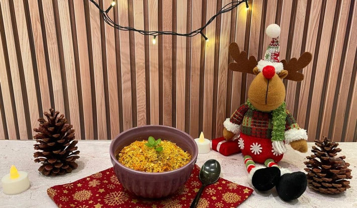 Fotografia em tons de vermelho com um pote roxo ao meio e a farofa de cenoura dentro.