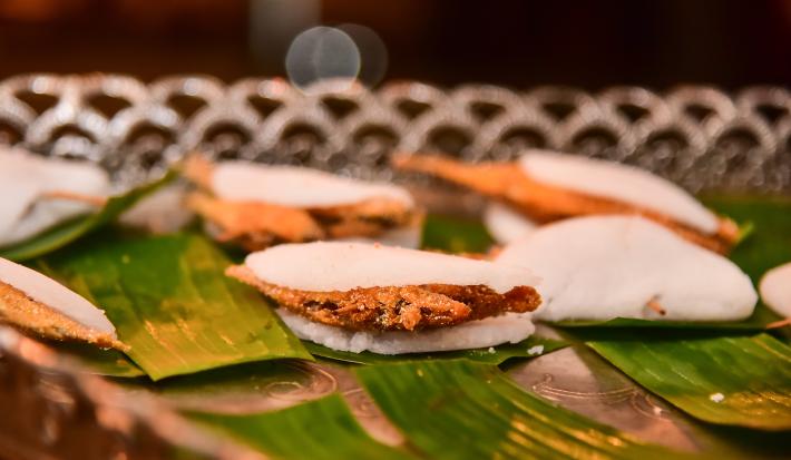 Foto da receita de Ginga com Tapioca. Observa-se algumas tapiocas recheadas de peixe empanado sobre folhas de bananeira.