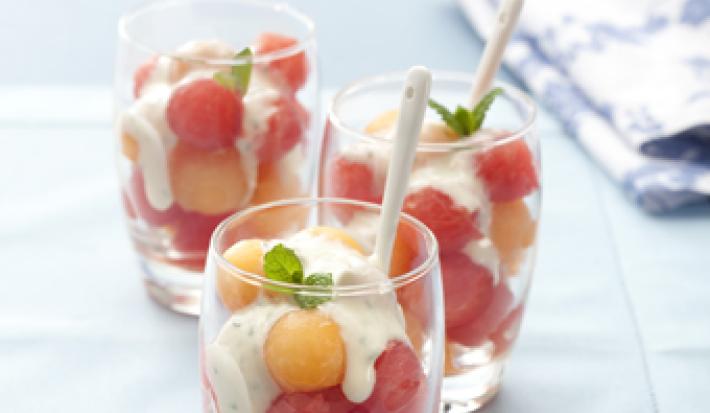 3 copos transparentes com bolinhas de melão e melancia com creme por cima