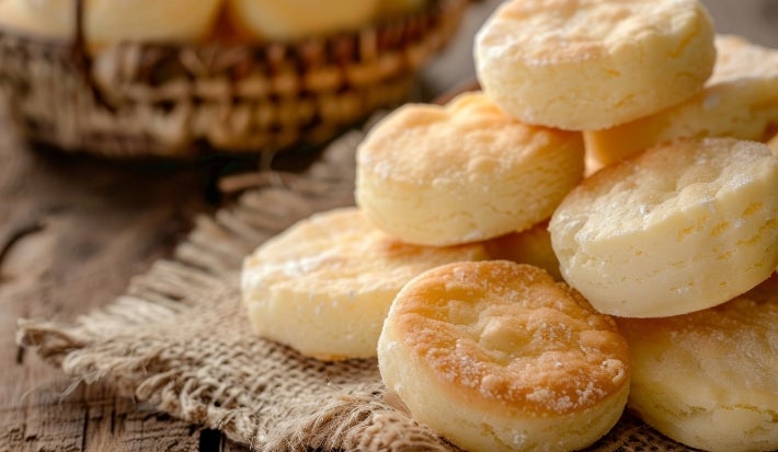 Em cima de uma mesa, prato com biscoitos dourados e crocantes.