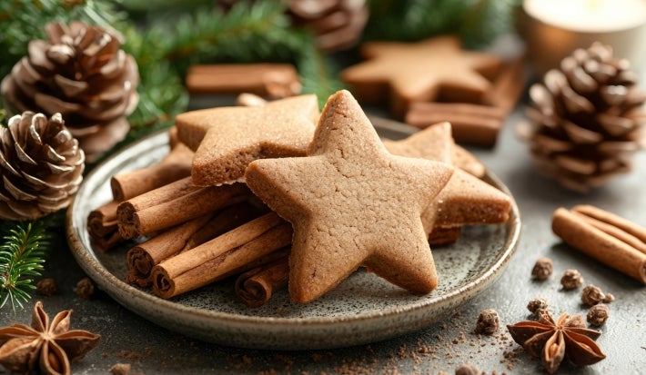 Em cima de uma mesa, prato redondo com biscoitos em formato de estrelas.