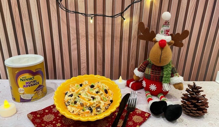 Fotografia em tons de amarelo e natal com um bowl amarelo ao centro e salada de salpicão dentro.