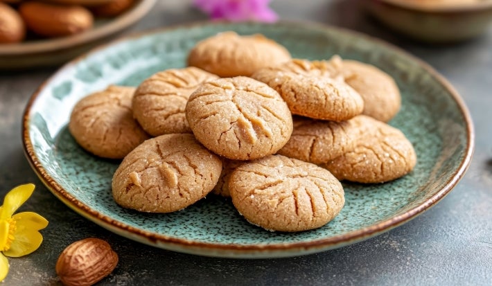 Em cima de uma mesa, biscoitos redondos crocantes com listas feitas com um garfo.